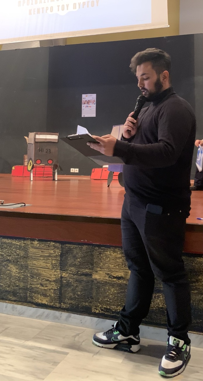 Apollon Papas speaking on stage with a microphone